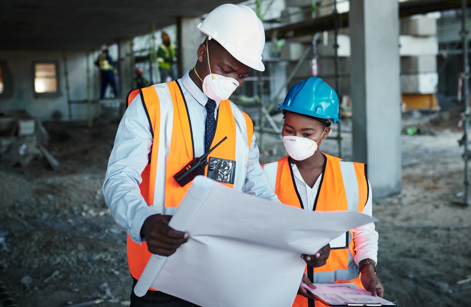Construction team reviewing building plans on site