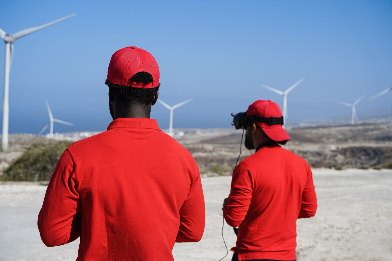 Technicians inspecting a wind turbine array